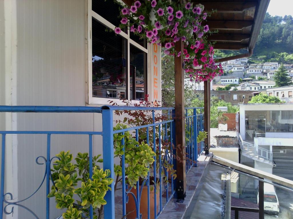 a balcony with flowers hanging from a building at Apartment Donend in Berat