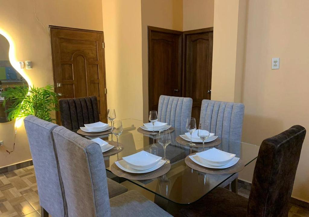 a dining room with a glass table and chairs at Family Apartment in San Cristóbal with 2 Bedrooms, 4 Beds, Living Room, Dining Area, Kitchen, Satellite WiFi and 1 Bathroom with Hot Water - CoralBay - Galápagos Home in Puerto Baquerizo Moreno