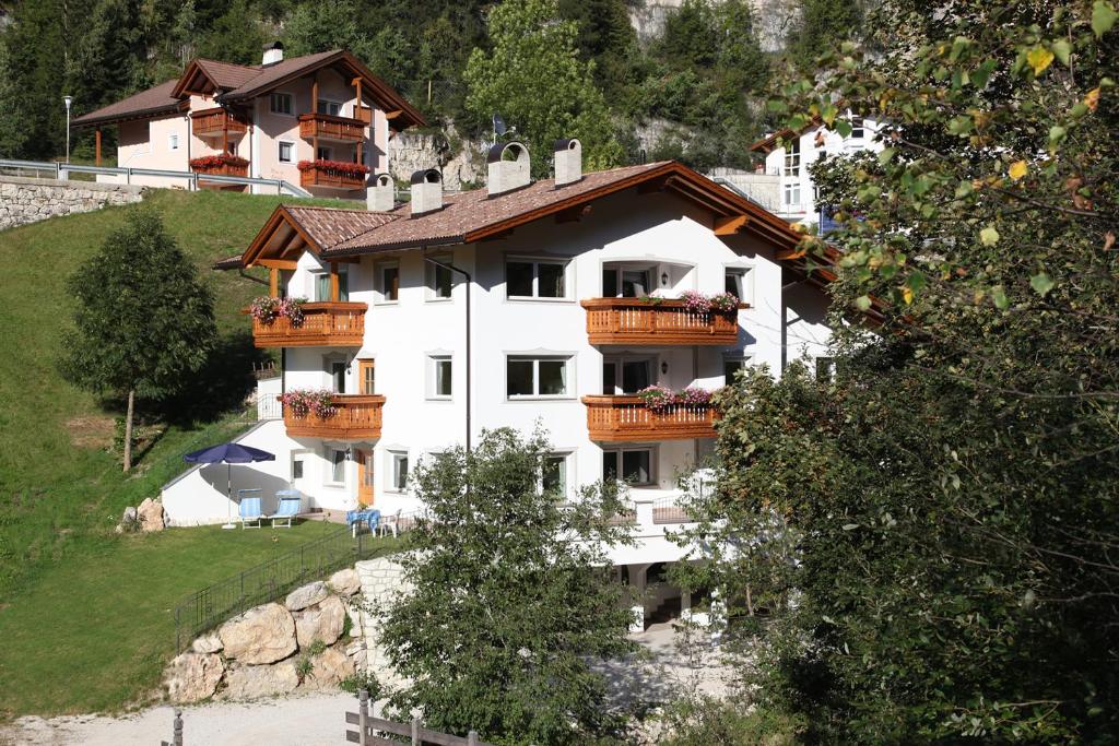 un grand bâtiment blanc avec balcon sur une colline dans l'établissement Villa Otto, à Santa Cristina Valgardena