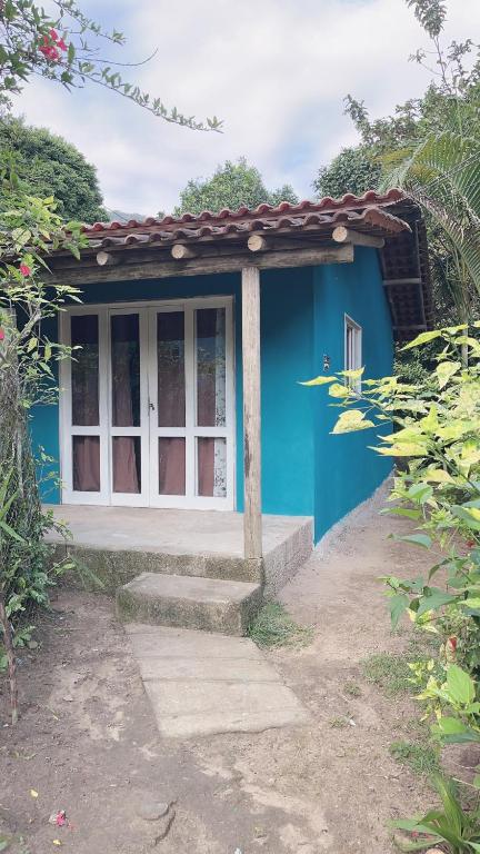 a blue house with a white window and steps at Casa da Jessica in Paraty