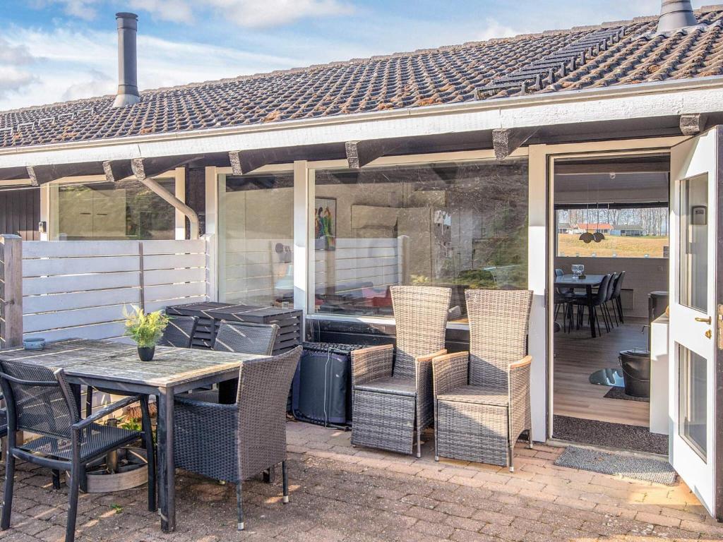 a patio with a grill and chairs and a table at 6 person holiday home in Aabenraa-By Traum in Aabenraa