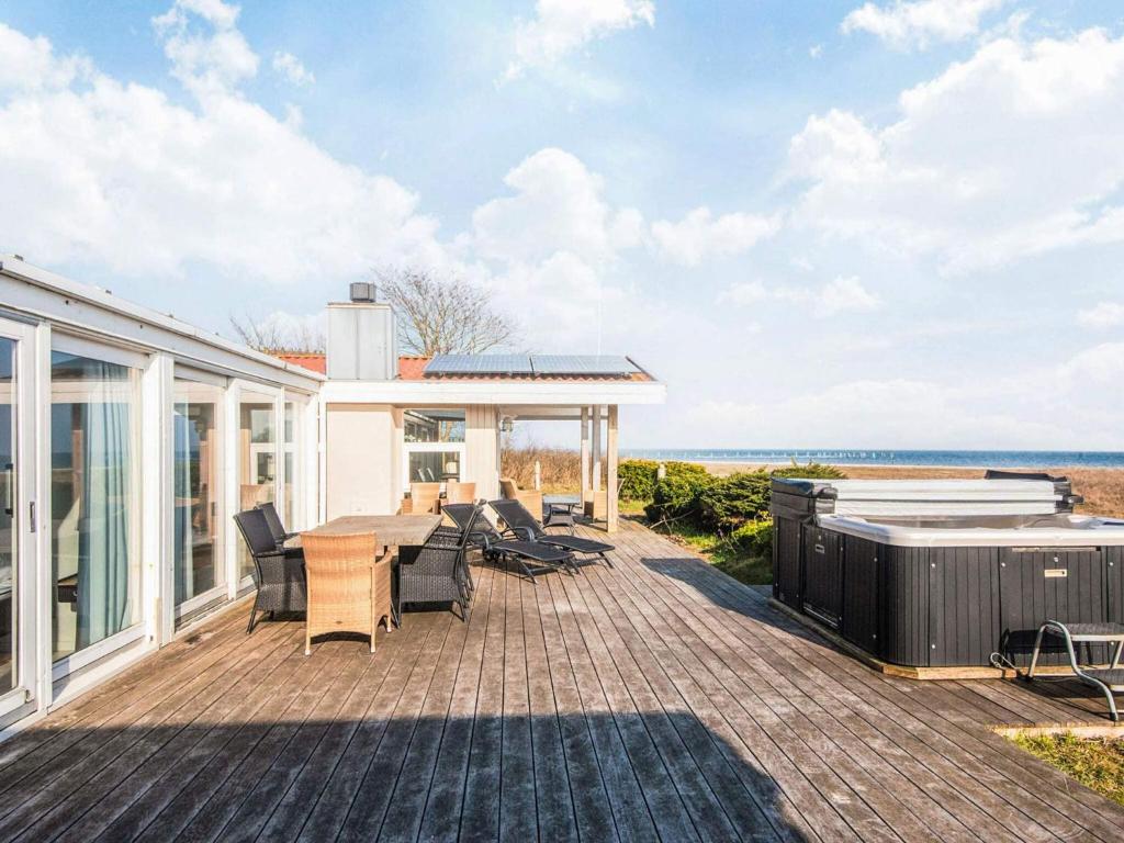 a house with a deck with a table and chairs at Luxury Seaside Retreat - By Traum Ferienwohnungen in Haderslev