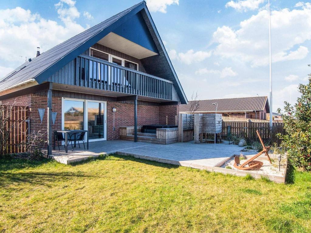 a brick house with a black roof and a patio at 12 person holiday home in Thyborøn-By Traum in Thyborøn