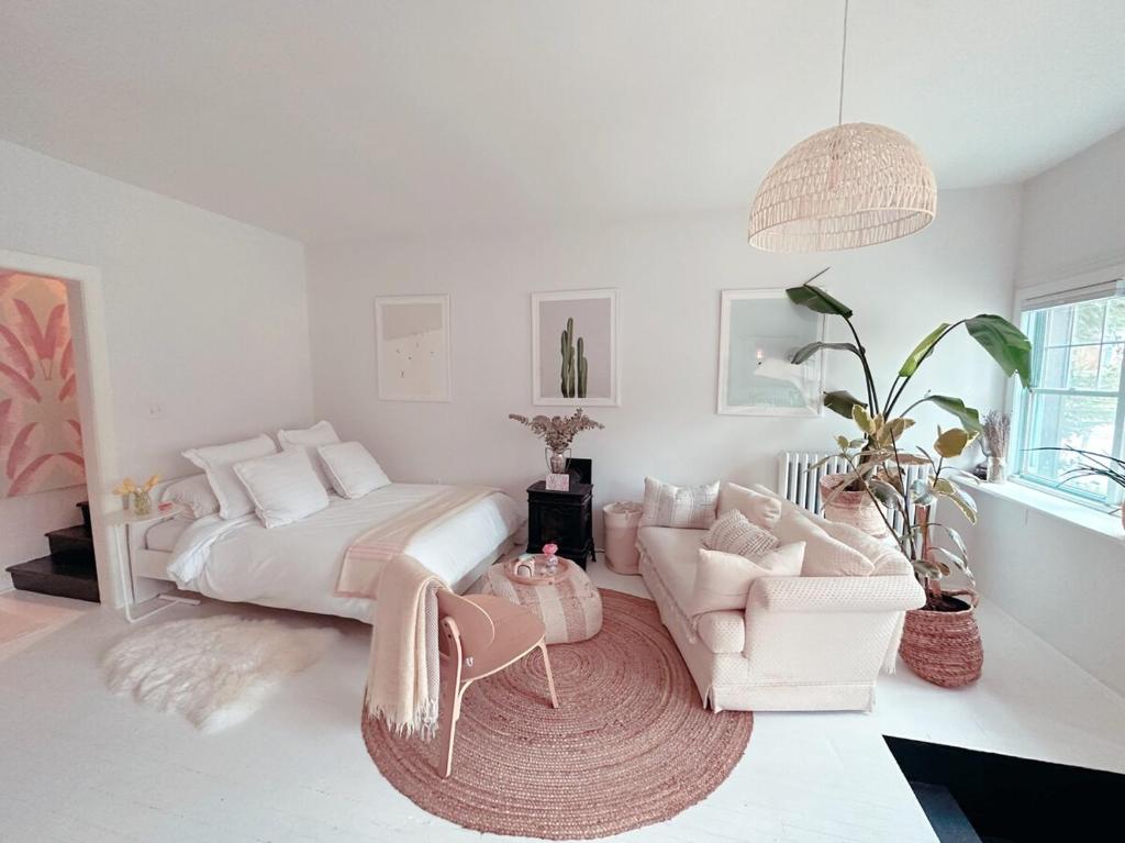 a bedroom with a bed and a couch and a chair at Cozy Coach House in Kitchener