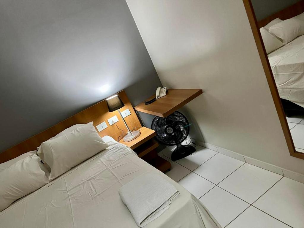 ein kleines Zimmer mit einem Bett und einem Spiegel in der Unterkunft Golden Dolphin Gran Hotel in Caldas Novas