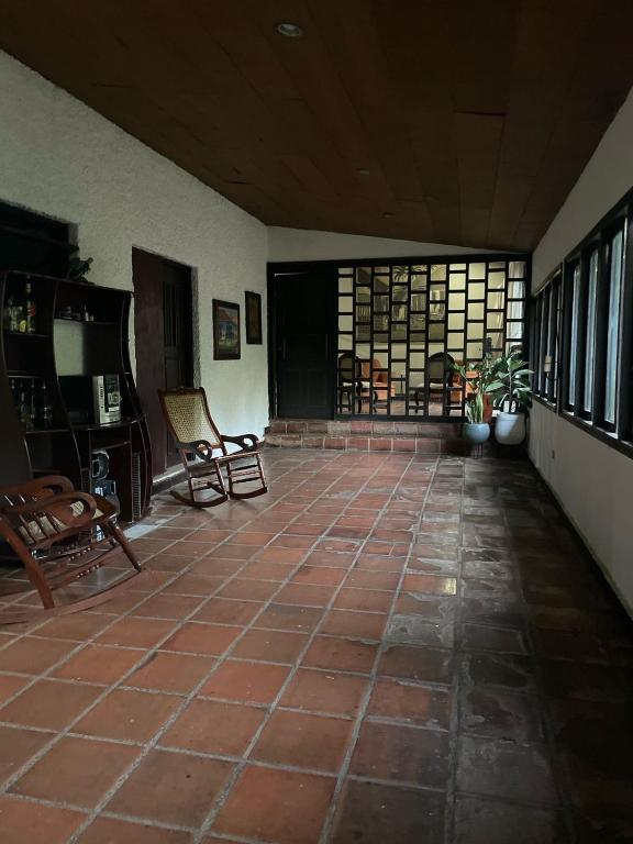 Zimmer mit Fliesenboden, Stühlen und einem Fenster in der Unterkunft Extraordinaria Casa Tranquila y Ventilada in León