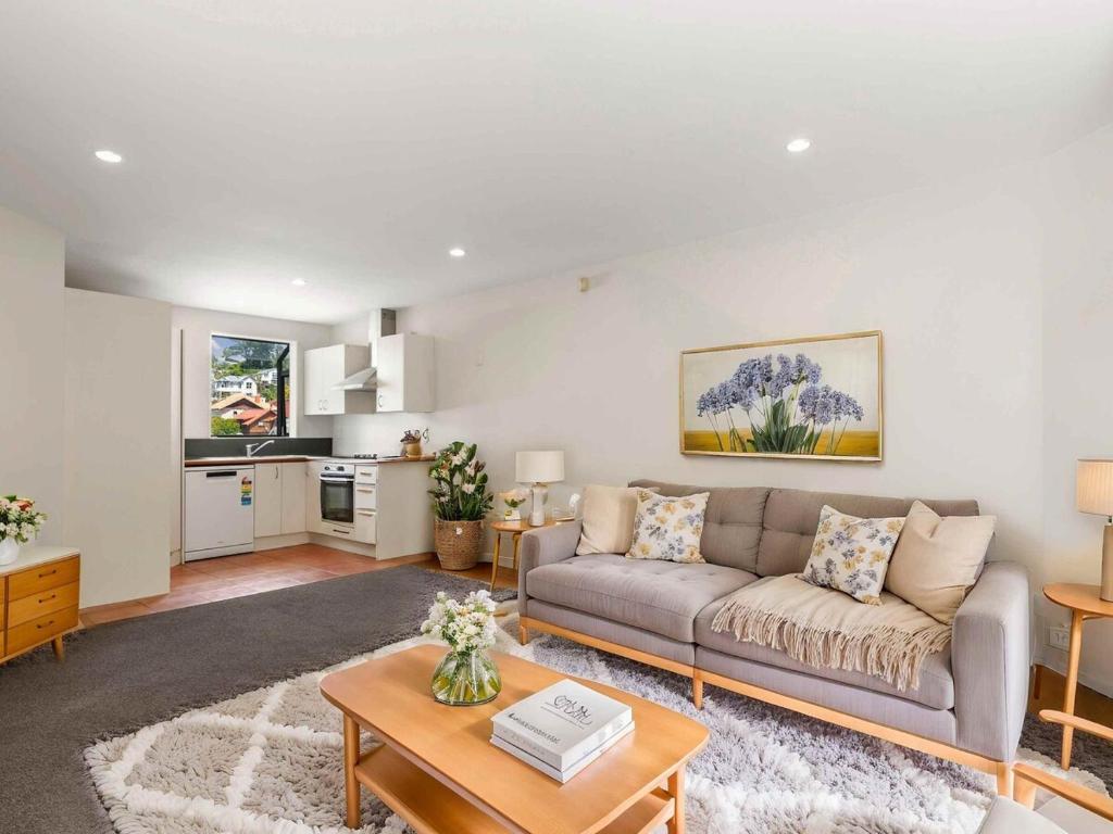 a living room with a couch and a table at Terrace Townhouse - Prime location & Free Parking! in Wellington