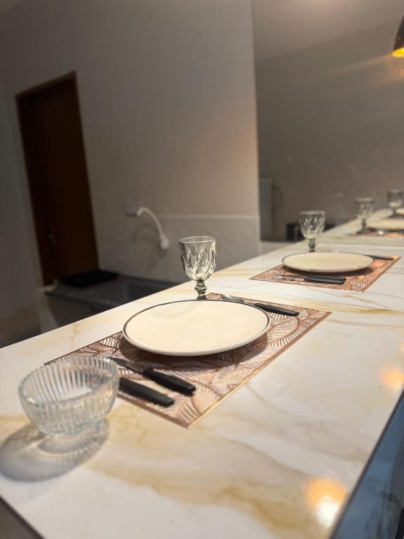 a table with plates and glasses on top of it at Flat mobiliado in Arapiraca
