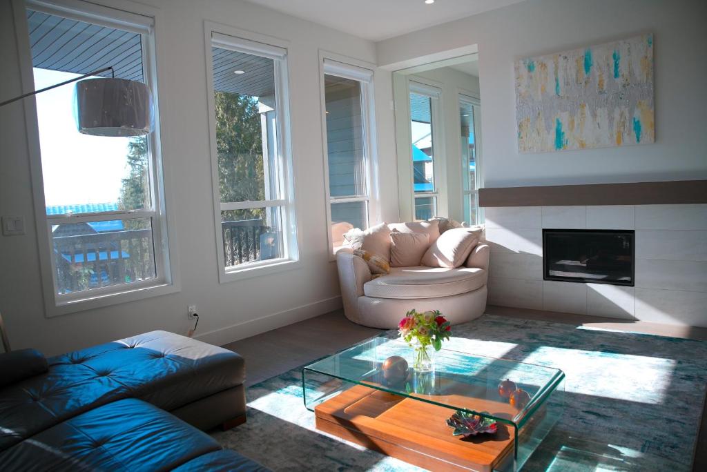 ein Wohnzimmer mit einer Couch und einem Glastisch in der Unterkunft Peaceful Coquitlam Escape, Modern New Home, Minutes to Transit in Coquitlam