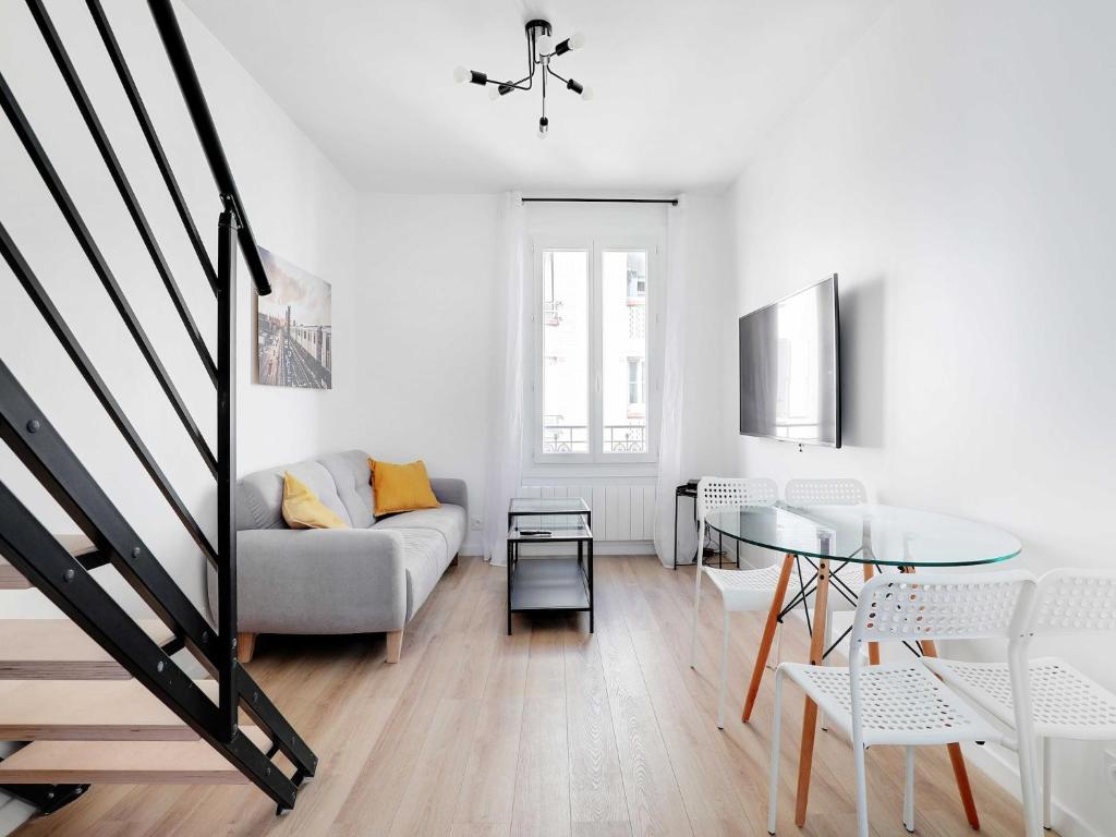 un salon avec un canapé et une table en verre dans l'établissement Cosy duplex - 2BDR 4P - Levallois So Ouest, à Levallois-Perret