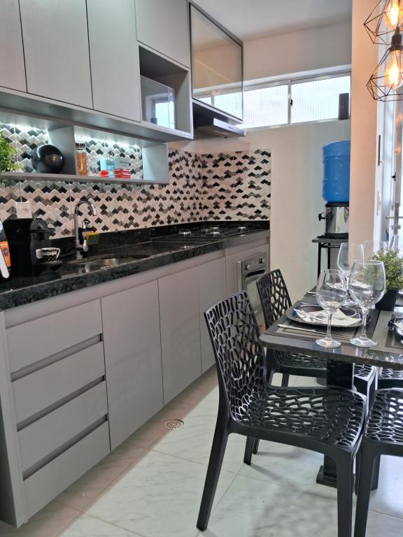 a kitchen with a table with wine glasses on it at Aeroporto 2 Quartos Self-chek in in Recife