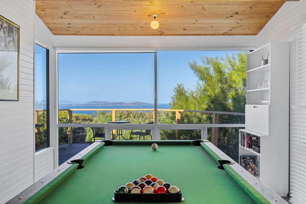 a pool table in a room with a balcony at Ocean Views 20kms from CBD Sleeps 10 in Kingston Beach