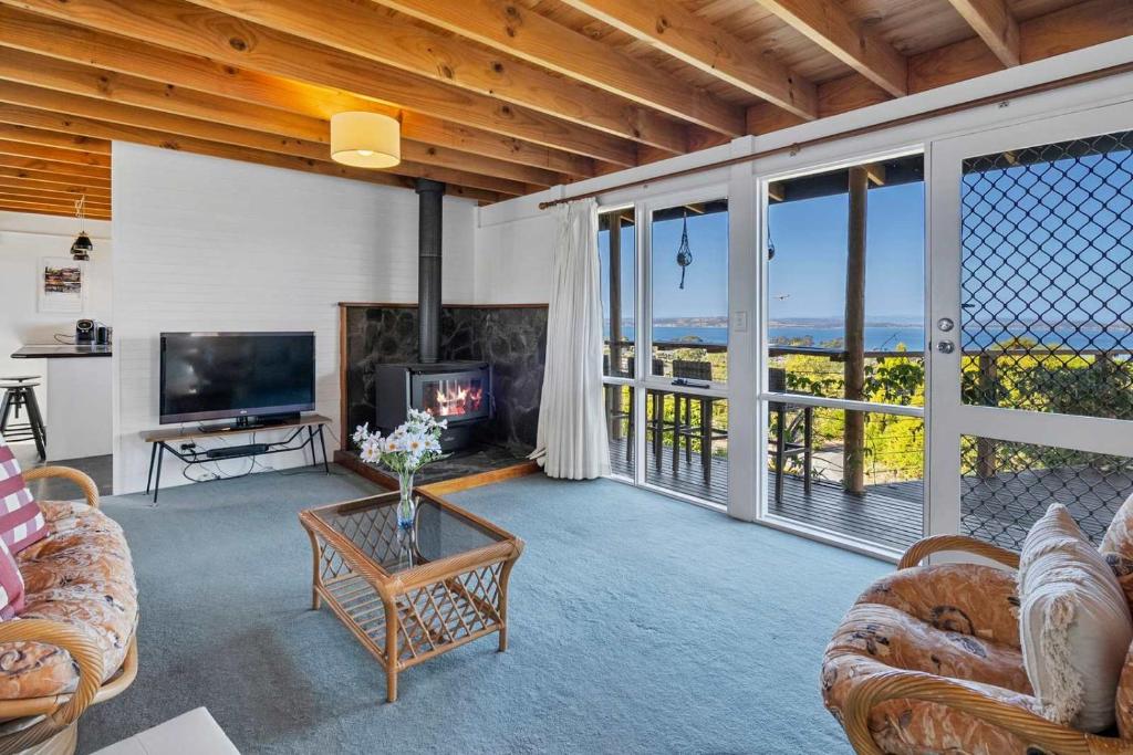 a living room with couches and a tv and windows at Ocean Views 20kms from CBD Sleeps 10 in Kingston Beach