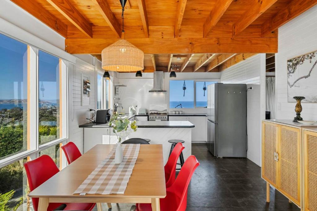 a kitchen with a wooden table and red chairs at Ocean Views 20kms from CBD Sleeps 10 in Kingston Beach