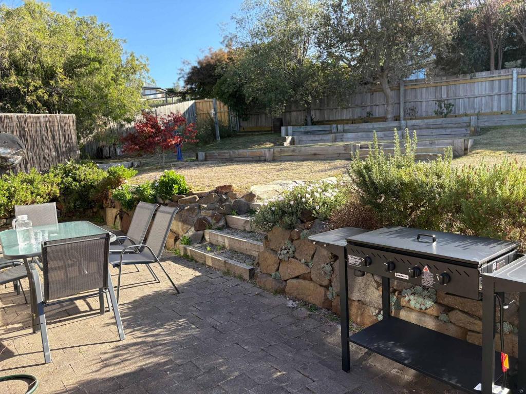 a patio with a table and chairs in a garden at Ocean Views 20kms from CBD Sleeps 10 in Kingston Beach