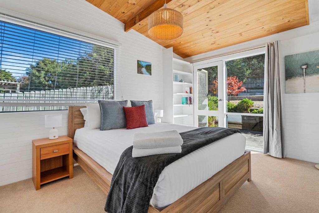 a bedroom with a bed and a large window at Ocean Views 20kms from CBD Sleeps 10 in Kingston Beach