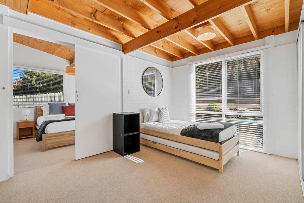 a bedroom with a bed in a room with windows at Ocean Views 20kms from CBD Sleeps 10 in Kingston Beach