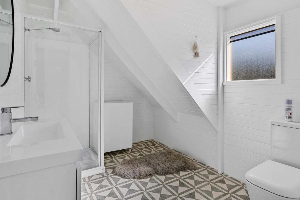 a white bathroom with a shower and a toilet at Ocean Views 20kms from CBD Sleeps 10 in Kingston Beach