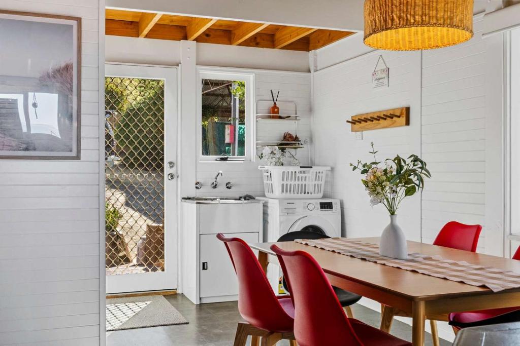 a dining room with a table and red chairs at Ocean Views 20kms from CBD Sleeps 10 in Kingston Beach