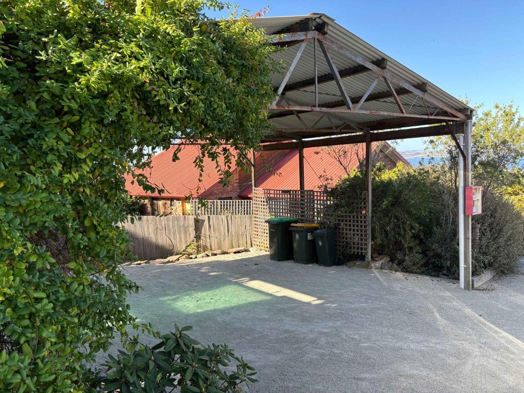 a covered parking lot with two trash cans in front of a building at Ocean Views 20kms from CBD Sleeps 10 in Kingston Beach