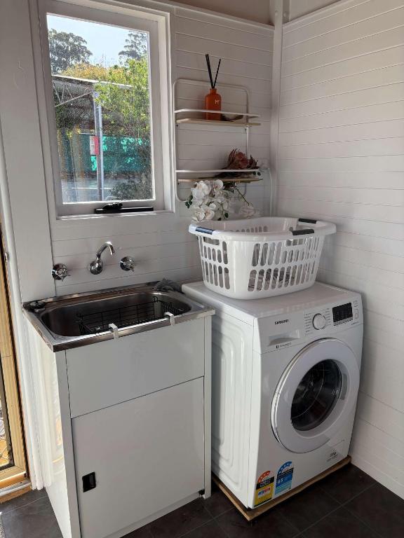 a laundry room with a washing machine and a sink at Ocean Views 20kms from CBD Sleeps 10 in Kingston Beach