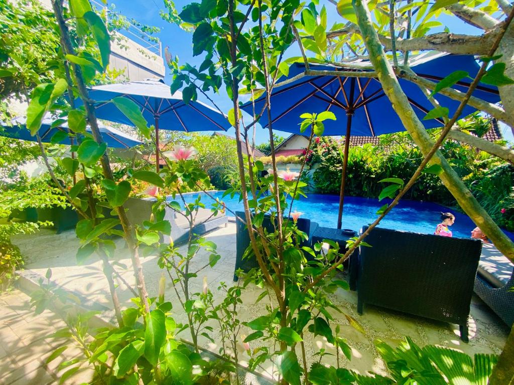 a pool with umbrellas and people in the water at Solaluna Beach Homestay in Amed