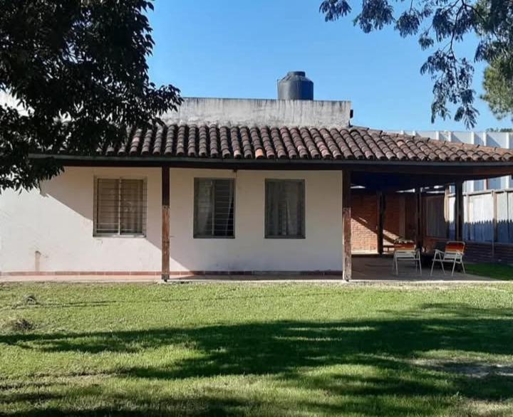 una piccola casa bianca con due sedie in un cortile di Quinta Ogarupa a Corrientes