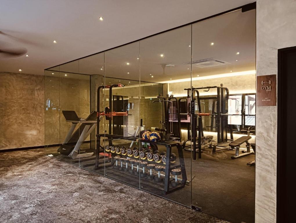 a gym with glass walls and a large mirror at BaBa Boutique House Langkawi in Pantai Cenang