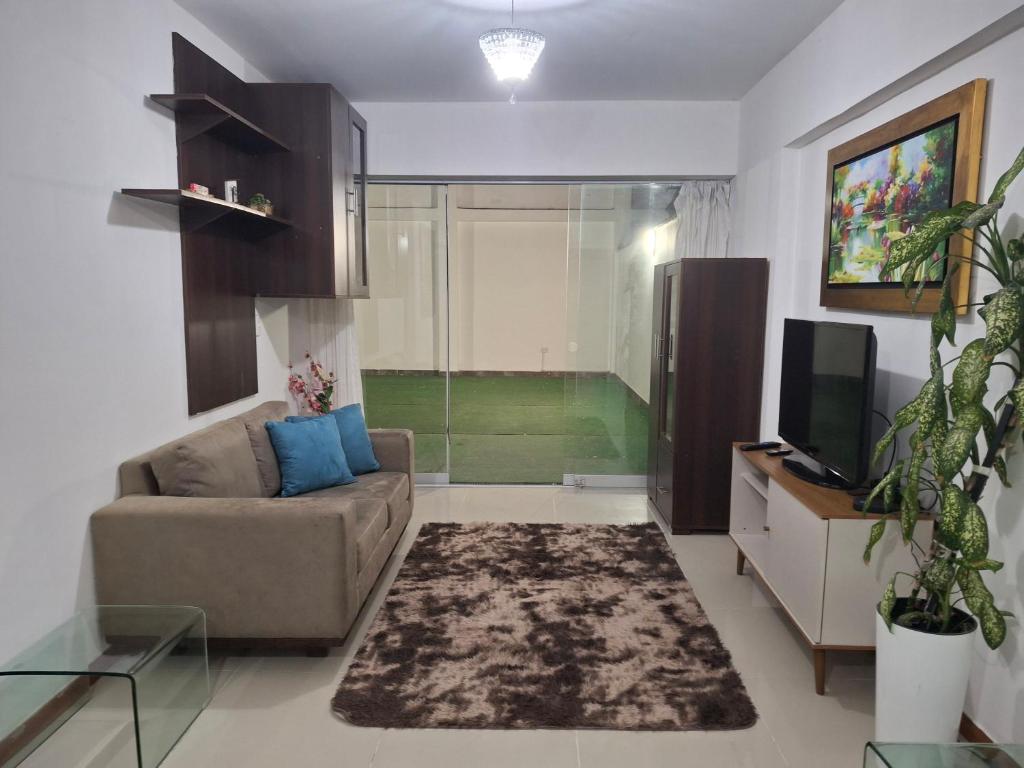 a living room with a couch and a television at Alojamiento Familiar en zona exclusiva de Chiclayo in Chiclayo