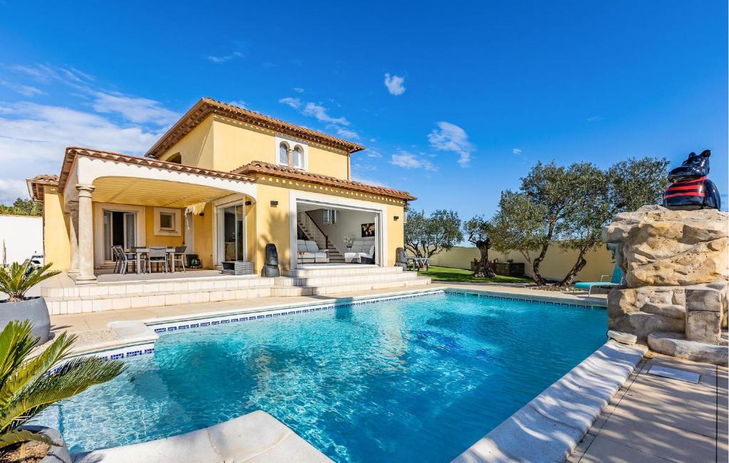 a villa with a swimming pool in front of a house at Beautiful Home In Marseillan in Marseillan