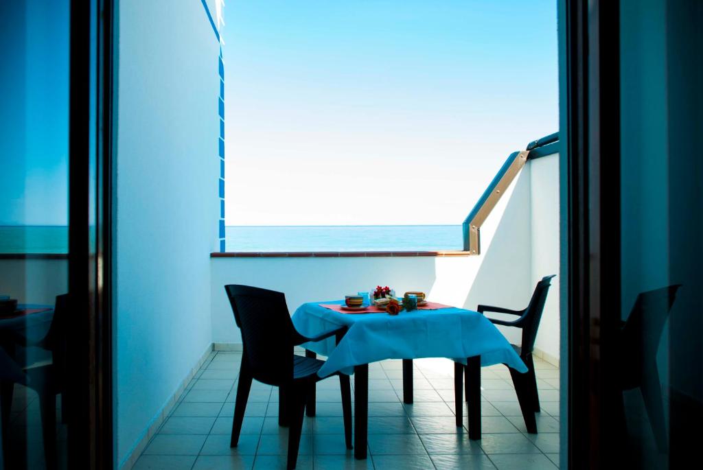 卡普多蘭多的住宿－In Riva al Mare B&B，窗户客房内的桌椅
