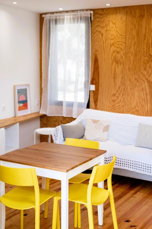 a dining room with a table and yellow chairs at Villa Cocoon Contis pour 2 - Jardin privatif - 900m Océan in Lit-et-Mixe