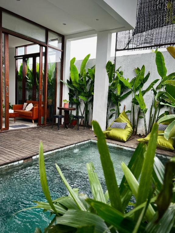 een zwembad voor een huis met planten bij The Green Atelier Bali in Jimbaran
