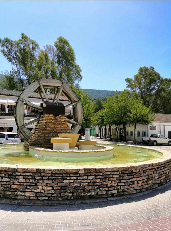a statue of a waterwheel on a stone wall at El bosque NOMADA 2 in El Bosque