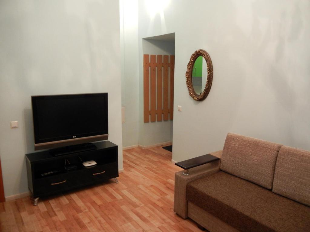 uma sala de estar com um sofá e uma televisão de ecrã plano em Apartment On Knyazya Romana 26 Center Lviv em Lviv
