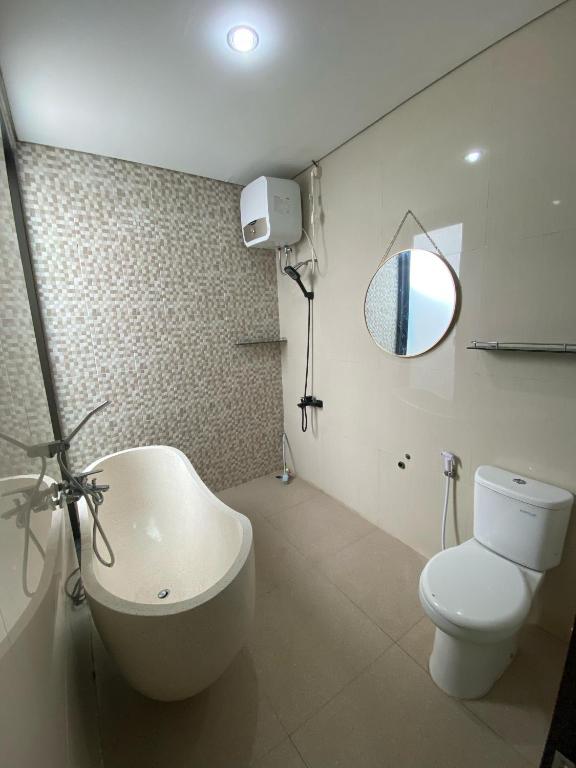 a bathroom with a white toilet and a sink at Villa Kila Rengganis Lombok in Prampuan