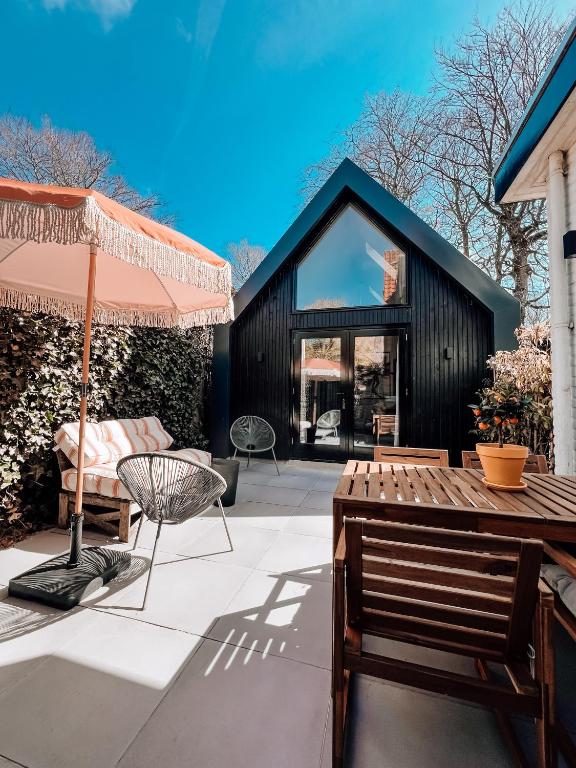 a patio with a wooden table and an umbrella at Studio Verver in Bergen