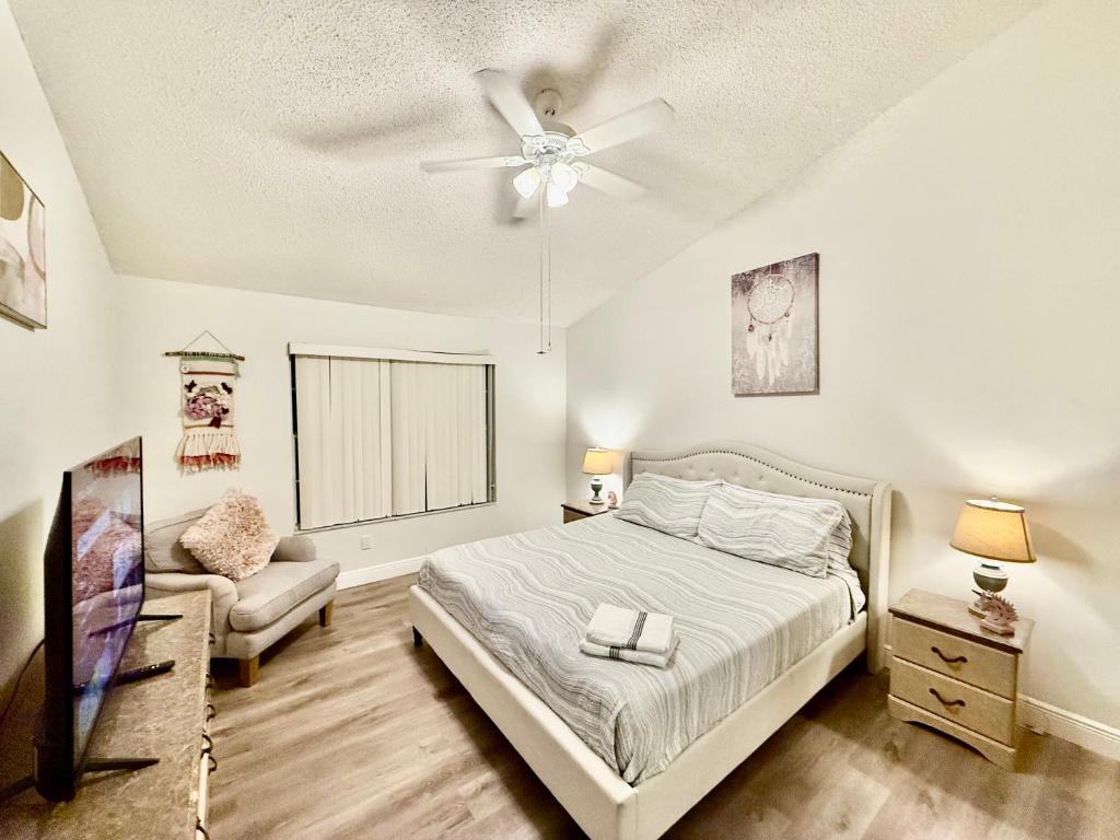 Un dormitorio con una cama y un ventilador de techo. en Grand Laguna 3BR Penthouse Near Disney Parks, en Kissimmee