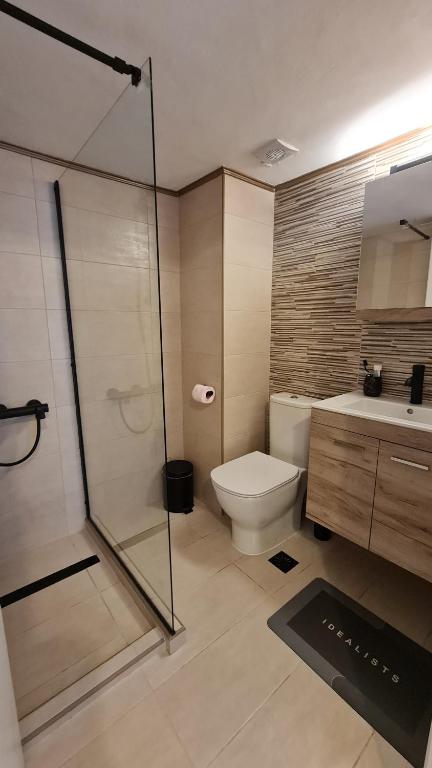 a bathroom with a shower and a toilet and a sink at Seaside Apartment - Charlie's House in Chalkida