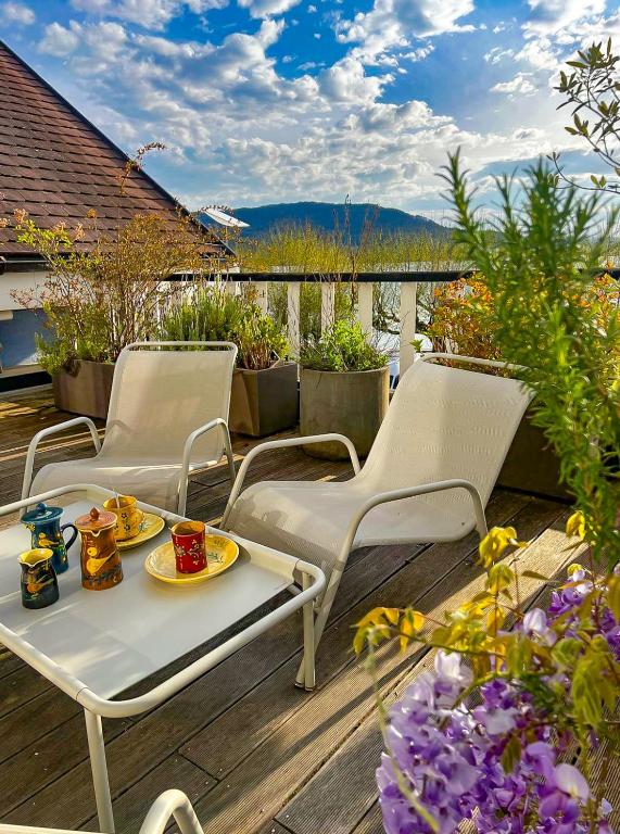 d'une terrasse avec 2 chaises et une table avec de la nourriture. dans l'établissement Comme chez soi 1, à Annecy
