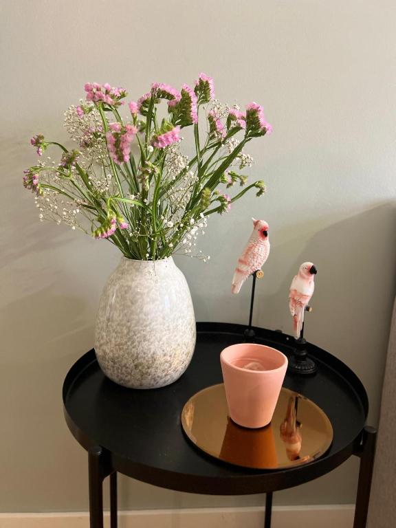 a black table with a vase and flowers on it at casa da vila 33 in Faro