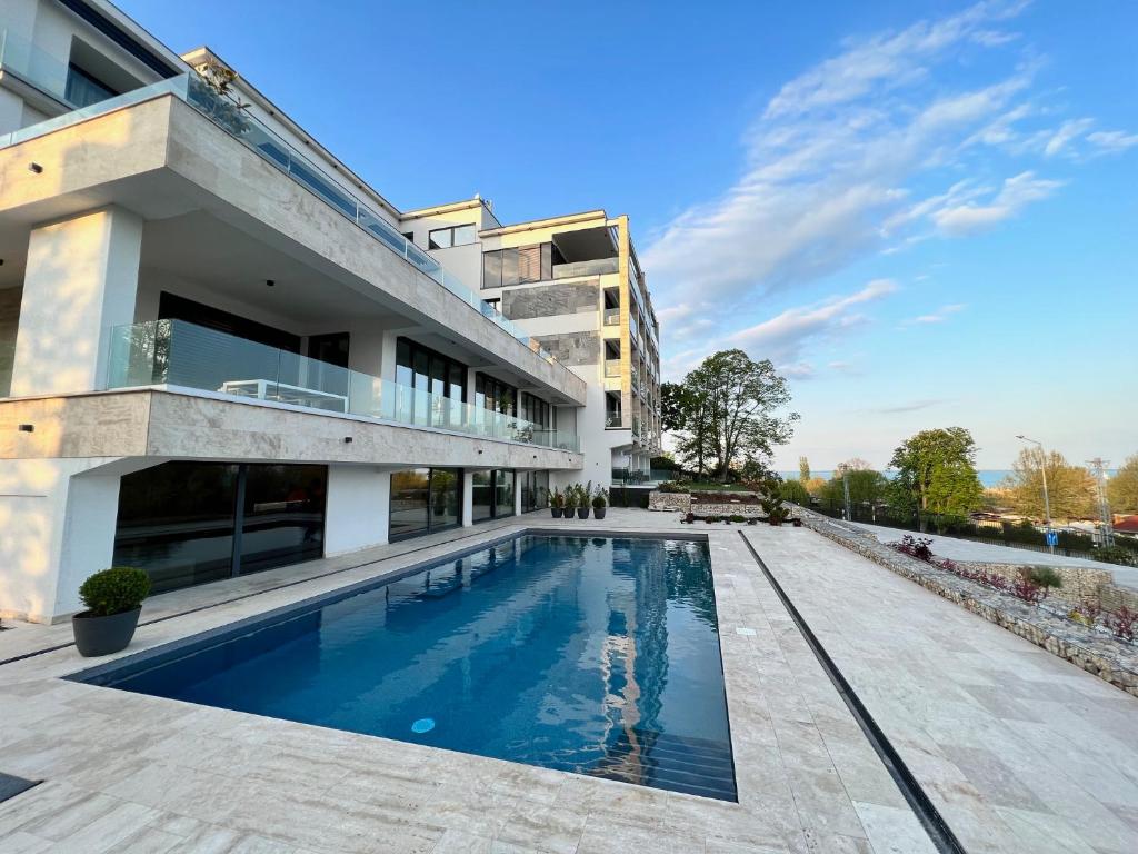 an outdoor swimming pool in front of a building at Sailor's Panorama Apartment in Alsóörs