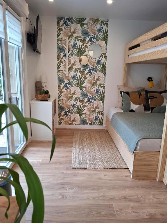 une chambre avec un lit avec un papier peint tropical dans l'établissement Suite Familiale près de Disney !, à Montévrain