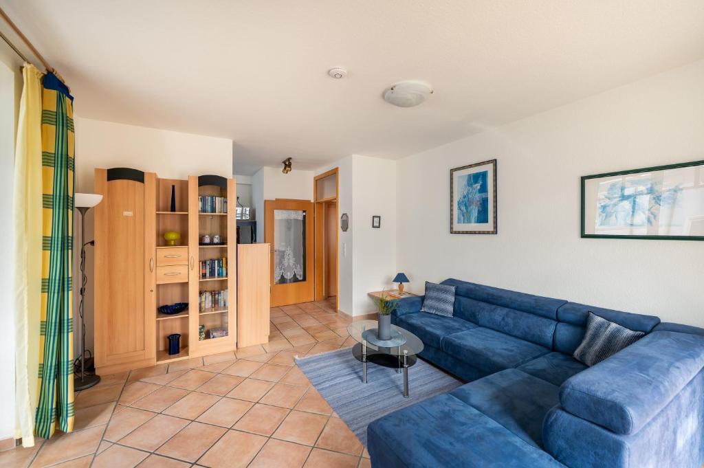 un soggiorno con un divano blu e un tavolo di Villa Hildegard Appartement 4 a Binz