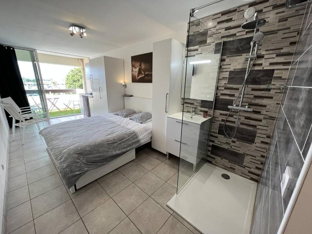 une chambre avec un lit et une douche en verre dans l'établissement Studio 2 couchage Cap d'Agde Naturisme CN040-633, au Cap d'Agde