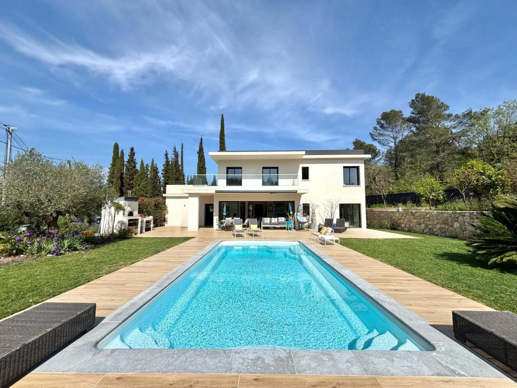 une piscine devant une maison dans l'établissement L'essence du sud avec 4 suites, piscines et four à pizza, à Opio