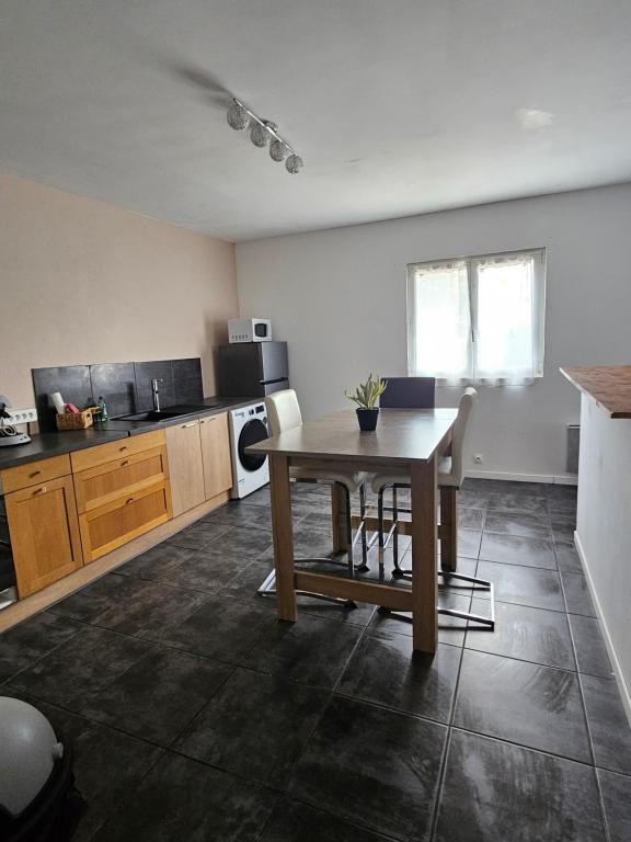 Una cocina con una mesa de madera y un comedor. en Gîte des Cyprès, en La Garde-Adhémar
