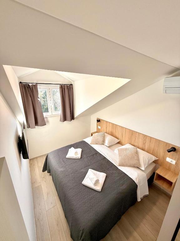 a bedroom with a bed with two towels on it at Cloud9 Apartments & Rooms in Močići