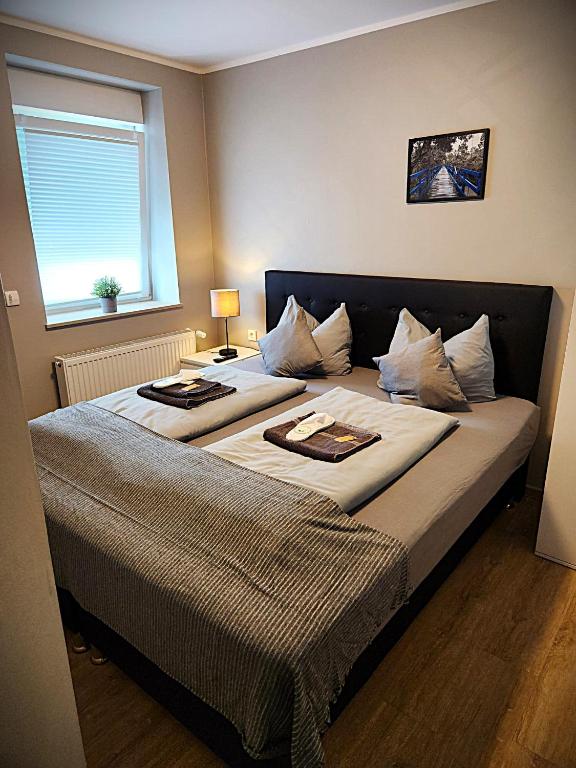 two beds in a hotel room with a window at Stadt Apartments Solingen in Solingen