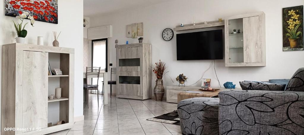 ein Wohnzimmer mit einer Couch und einem Fernseher an der Wand in der Unterkunft Casa DàCà in Marrùbiu
